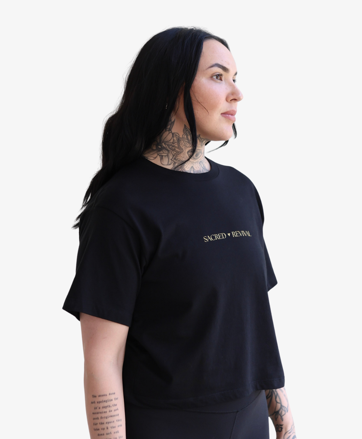 Woman wearing the black Tree of Life boxy tee with the gold wordmark, front view