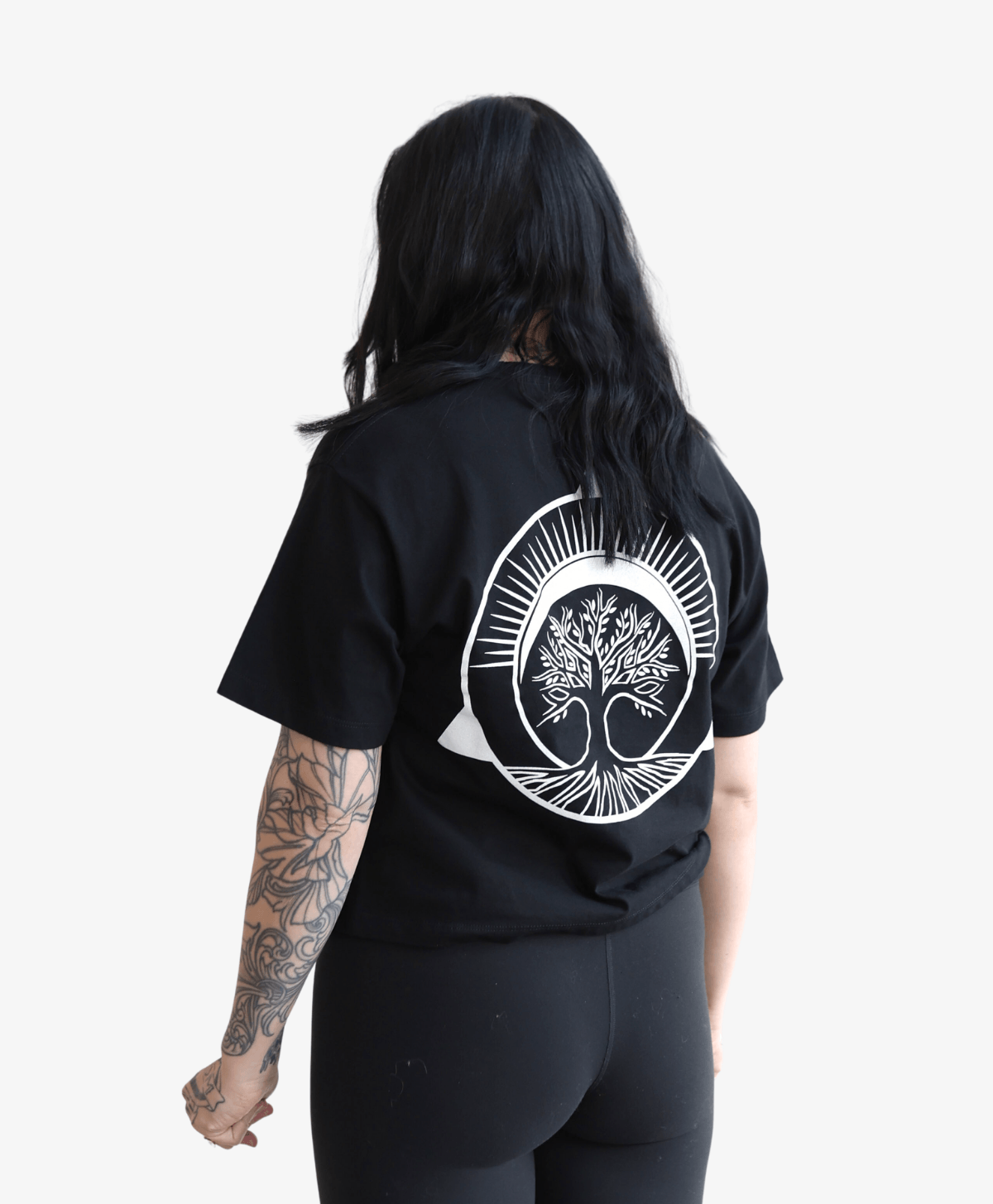 Woman seen from behind wearing the black Tree of Life boxy tee, full-length view