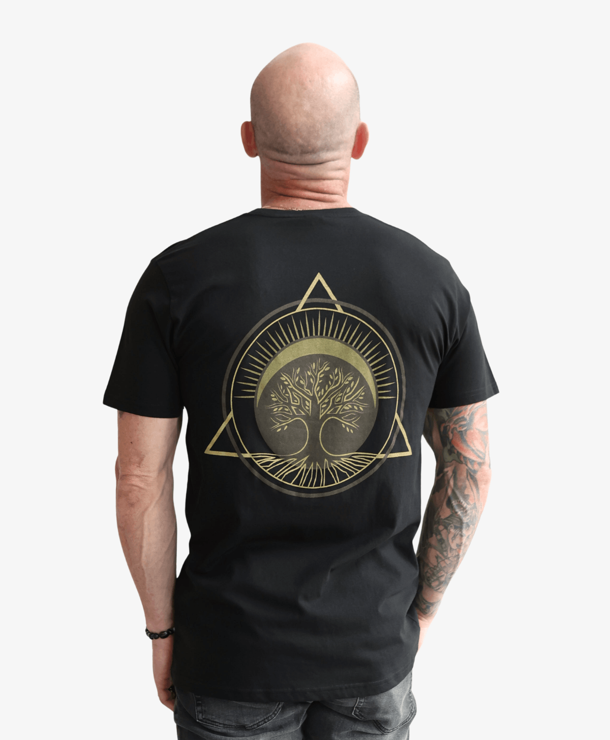 Man seen from behind wearing the black Tree of Life tee with the gold symbol