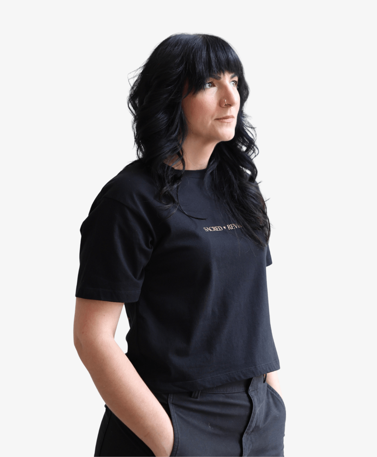 Woman wearing the black Tree of Life boxy tee with the gold wordmark, turned to the side