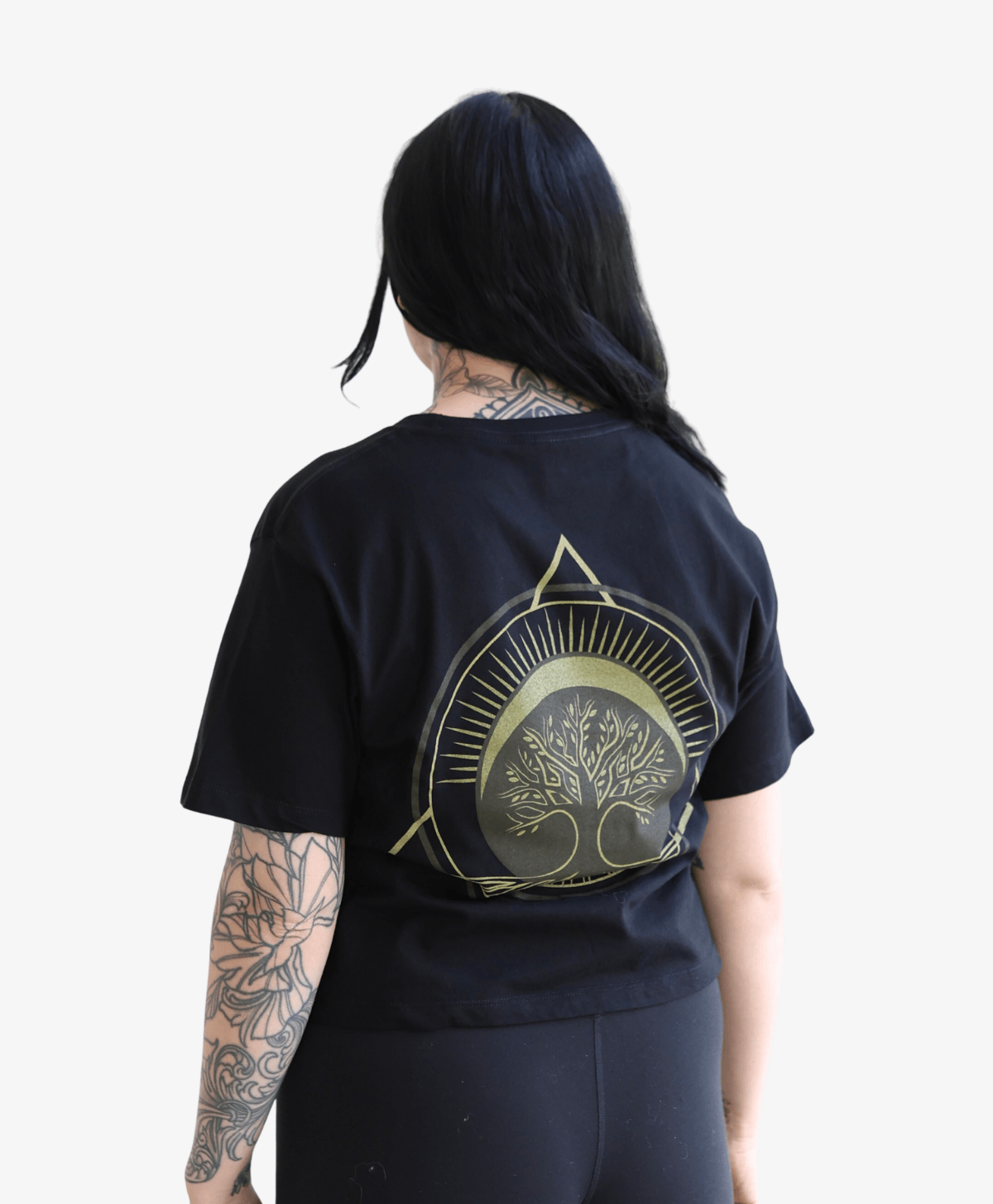 Woman seen from behind wearing the black Tree of Life boxy tee with the full-colour symbol
