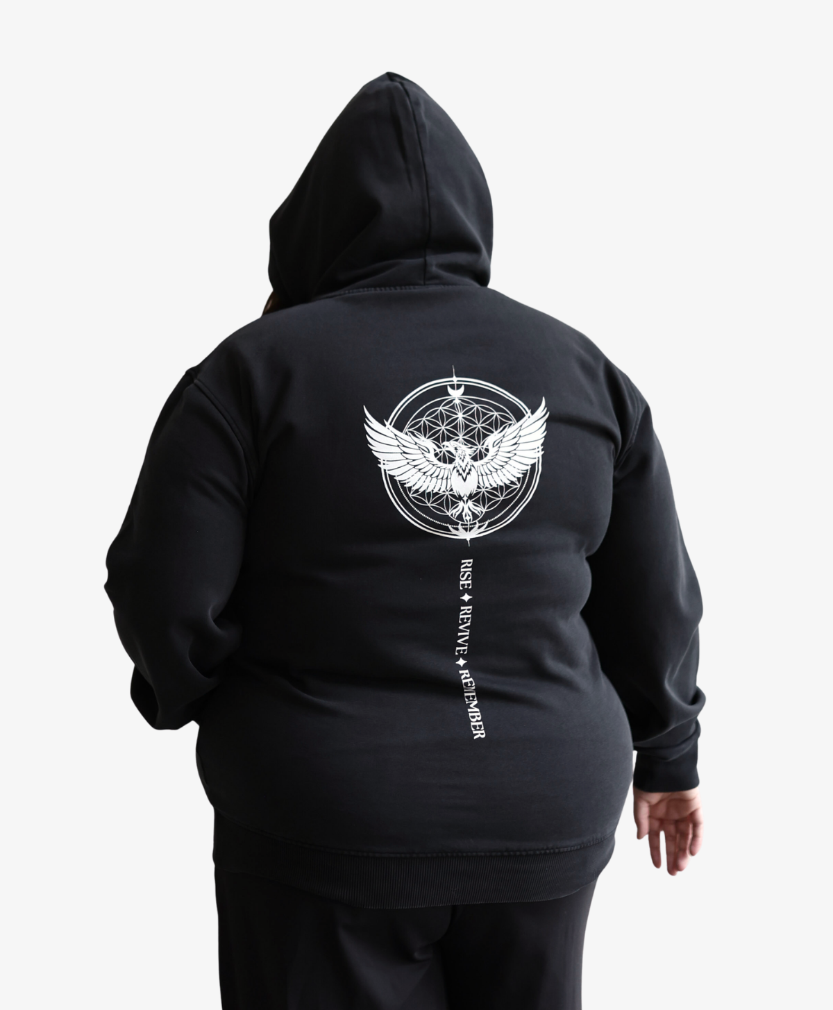 Woman seen from behind wearing the black Phoenix Rising hoodie with the hood up